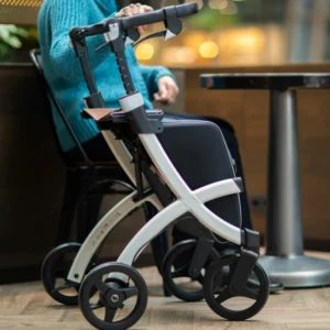 A woman sitting in a chair with a walker.