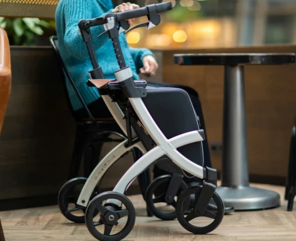 A woman sitting in a chair with a walker.