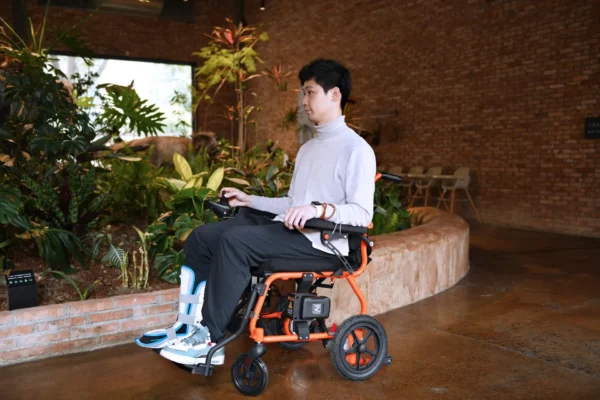 A man sitting in a wheelchair with a laptop.