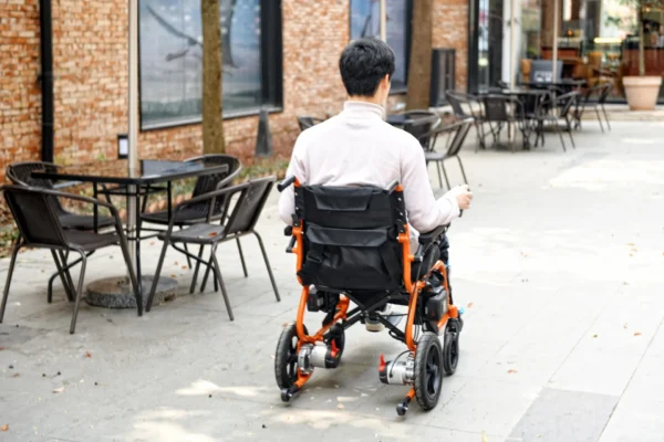 A man in a wheelchair on the sidewalk.