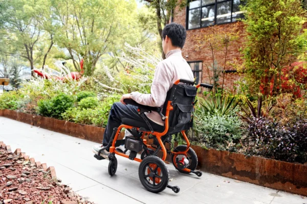 A man sitting on an orange and black wheelchair.