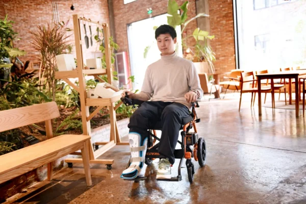 A man in white shirt riding on a wheelchair.