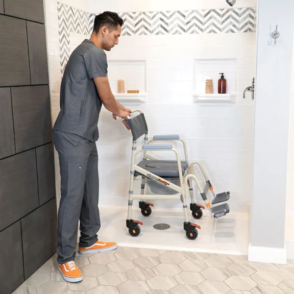 A man in grey scrubs and an orange medical cart.