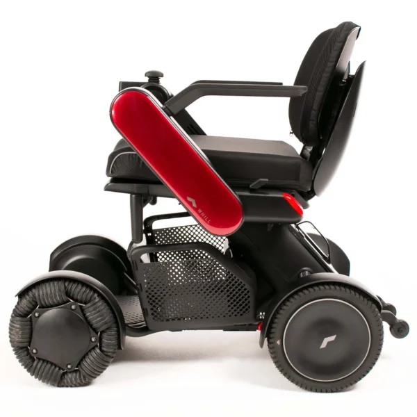 A black wheelchair with red seat and wheels.