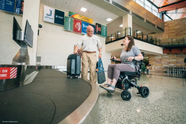 A man and woman with luggage at an airport.