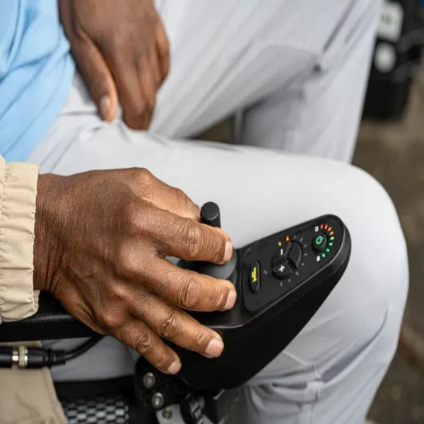 A person sitting on the ground holding a remote control.