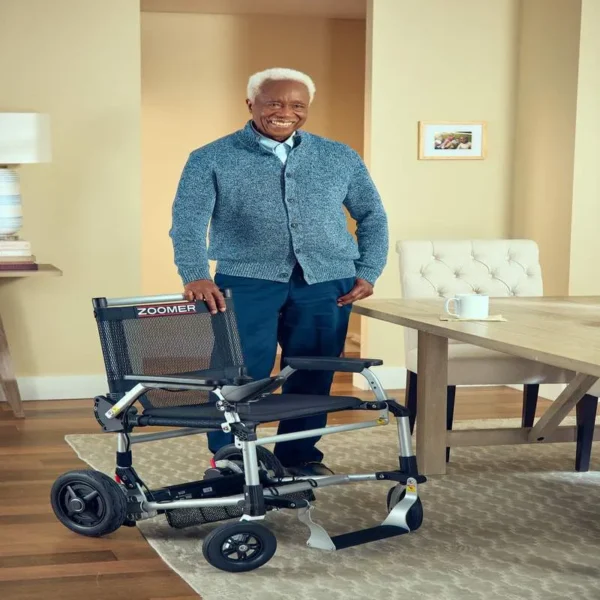 A man standing next to a wheelchair in a room.