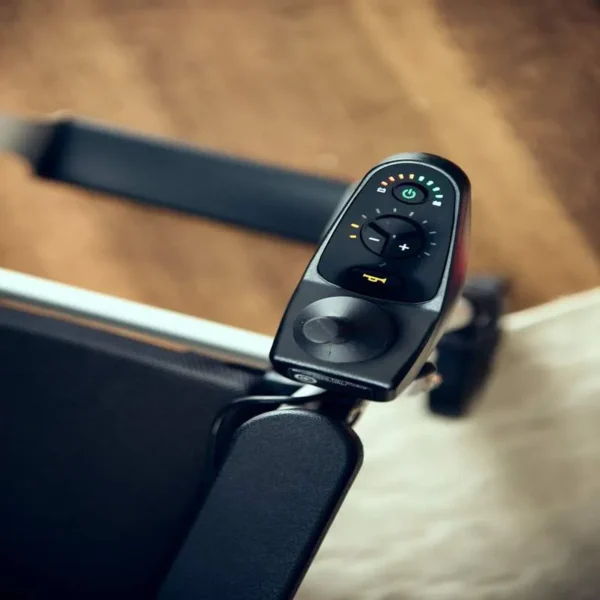 A remote control is attached to the handle of a laptop.